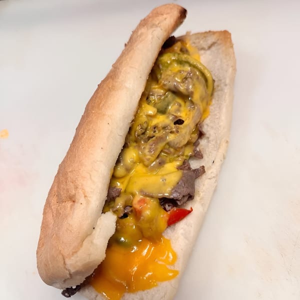 A&J ITALIAN DELI's cheesesteak sandwich, filled with steak, melted cheese, and red peppers.